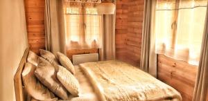 1 dormitorio con cama con almohadas y ventana en Vue imprenable et jacuzzi 4 Etoiles, en Bagnères-de-Bigorre