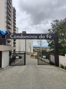ein Tor mit einem Schild, das Condomino de fa liest in der Unterkunft Apto a 300 metros da Canção Nova. Condomínio da Fé in Cachoeira Paulista