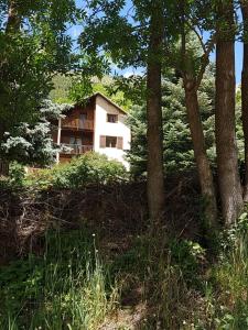 una casa en medio de un bosque de árboles en Agréable appartement au calme avec vue montagne, commune de Le Monêtier les Bains - Le Freyssinet, en Les Guibertes