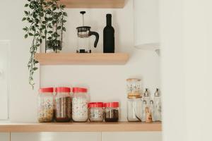 a kitchen shelf with jars and a bottle of wine at Terrazzo house in Subotica