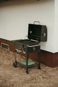 a grill sitting on a stand next to a wall at Terrazzo house in Subotica