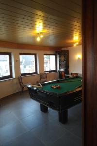 Zimmer mit einem Billardtisch in einem Zimmer mit Fenstern in der Unterkunft Osteria Mediterranean in Freirachdorf