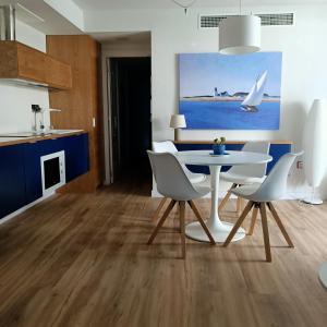 カルボネラスにあるVENTANA AL MARの白いテーブルと椅子のあるキッチンとダイニングルーム