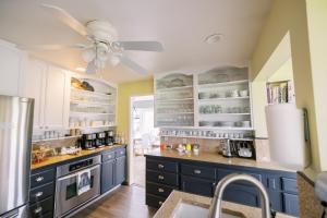 a kitchen with blue cabinets and a ceiling fan at Trumpeter Inn in Friday Harbor