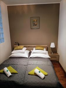 ein Schlafzimmer mit einem großen Bett mit gelben und weißen Kissen in der Unterkunft Cleopatra Apartment Budapest in Budapest