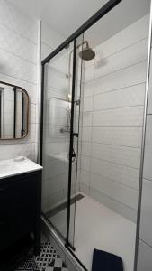 a shower with a glass door in a bathroom at Epernay, appartement champagne et art déco in Épernay