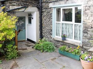 una casa con una puerta verde y una ventana en Caxton Nook, en Windermere