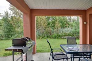 a screened in porch with a grill and a table and chairs at *Nouveauté* Foyer au bois, Plage, Montagne et + in Magog-Orford