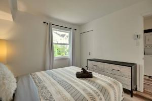 een witte slaapkamer met een bed en een raam bij *Nouveauté* Foyer au bois, Plage, Montagne et + in Magog-Orford