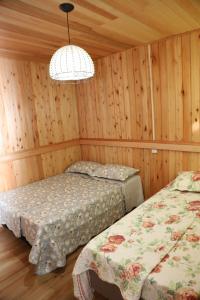 a bedroom with two beds and a chandelier at Casarão Biazolli in Farroupilha