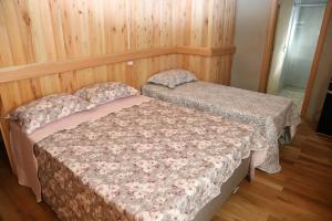 two beds in a room with wooden walls at Casarão Biazolli in Farroupilha