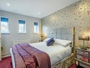 a bedroom with a large bed with a floral wallpaper at The Old Bank in Mundesley