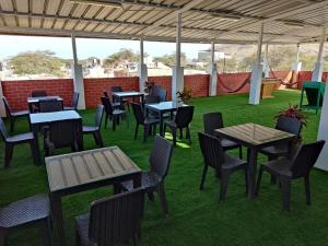 eine Gruppe von Tischen und Stühlen auf einer Terrasse in der Unterkunft HOTEL PUNTA PARIÑAS-TALARA-PERU in Talara