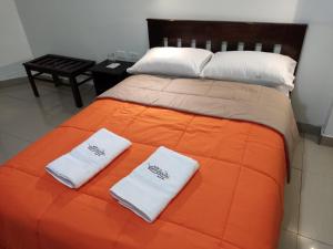 ein Bett mit zwei weißen Handtüchern darüber in der Unterkunft HOTEL PUNTA PARIÑAS-TALARA-PERU in Talara