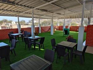 un patio con mesas y sillas en el césped en HOTEL PUNTA PARIÑAS-TALARA-PERU, en Talara