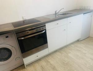 a kitchen with a stove and a sink and a washing machine at Ferienwohnung in Gersheim / bis 4 Personen in Gersheim