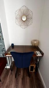 a room with a desk with a blue chair and a fan at Epernay, appartement champagne et art déco in Épernay