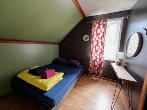 a bedroom with a blue bed in a room with a window at Chill Shack - Auberge Jeunesse in Sainte-Anne-des-Monts