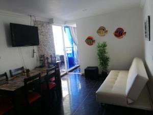 a living room with a white couch and a television at Apartamento Boutique Cartagena in Cartagena de Indias