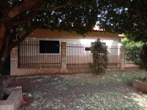 a fence in front of a house with a tree at RECANTO DO ALVORADA in Dourados