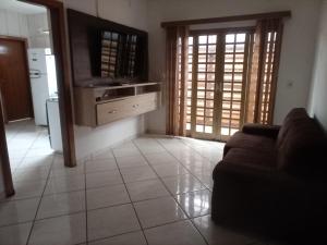ein Wohnzimmer mit einem Sofa und einer Küche in der Unterkunft RECANTO DO ALVORADA in Dourados