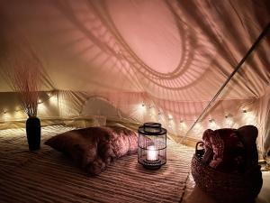 a bedroom with a tent with a candle on a bed at Lux Glamping, Lammas in Halliste