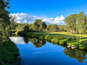 a river with a boat in the middle at Lux Glamping, Lammas in Halliste +10 photos