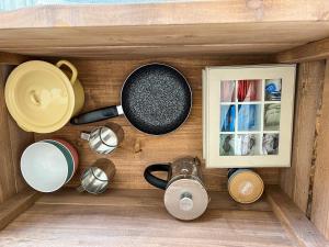 a wooden shelf with pots and pans and a picture at Lux Glamping, Lammas 