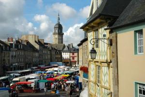 Le Ty Douar في Coëtmieux: شارع المدينة مزدحم مع برج الساعة في الخلفية