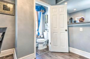 a bathroom with a toilet and a white door at Charming Baltimore Home with Deck and Fire Pit! in Baltimore