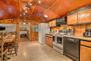 cocina con techo de madera, mesa y nevera en Plum Creek Retreat with Beach near Johnson Lake, 