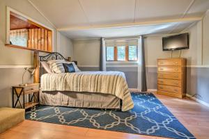 1 dormitorio con 1 cama con alfombra azul y TV en Plum Creek Retreat with Beach near Johnson Lake, 