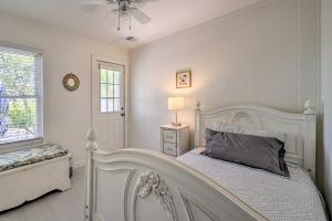 a white bedroom with a white bed and a window at Bright Carolina Beach Cottage with Yard and Grill in Carolina Beach