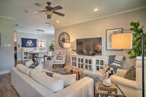 a living room with a couch and a tv at Baton Rouge Game Day House with Chic Yard Space in Baton Rouge