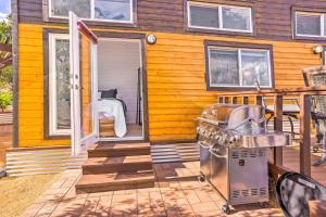 une maison jaune avec un barbecue sur une terrasse dans l'établissement Modern Clarkdale Tiny Home on Mingus Mountain, à Clarkdale