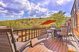 une terrasse avec une table, des chaises et un parasol dans l'établissement Modern Clarkdale Tiny Home on Mingus Mountain, à Clarkdale