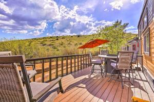 a deck with a table and chairs and an umbrella at Modern Clarkdale Tiny Home on Mingus Mountain in Clarkdale