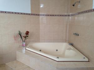 a bath tub in a tiled bathroom at Hotel Los Cocos in Chimbote