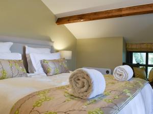 a bedroom with a large bed with towels on it at The Bothy in Beetham