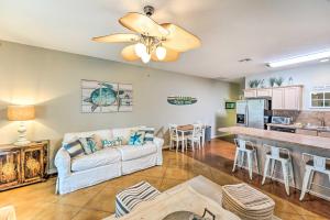 a living room with a couch and a kitchen at Sunny Townhome with Pool Access about 1 Mi to Beach in Padre Island