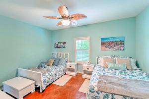 帕德雷岛Sunny Townhome with Pool Access about 1 Mi to Beach的带两张床和吊扇的卧室