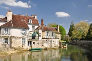 a group of buildings sitting next to a river at Appartement spacieux et lumineux au centre ville in Tonnerre