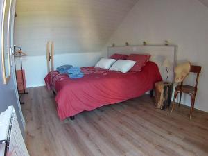 una camera da letto con un grande letto con una coperta rossa di Le Ty Douar a Coëtmieux