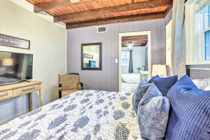 a bedroom with a bed and a television and a bathroom at Waterfront Home Spectacular On-Site Fishing! in Panacea