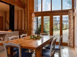 a dining room with a wooden table and chairs at Ivy Todd Barn in Ashdon