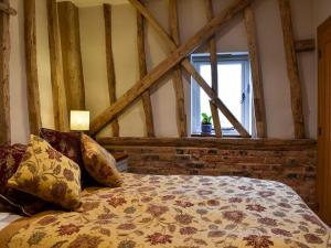 a bedroom with a bed and a window at Ivy Todd Barn in Ashdon