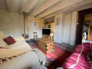a living room with a bed and a tv at The Barn, Higher Boden, Manaccan, Helston, Cornwall in Helston