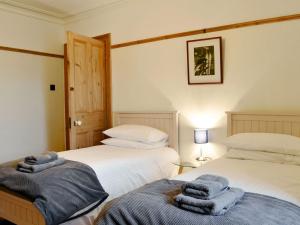 two beds with towels on them in a bedroom at Kingswood in Whitehaven