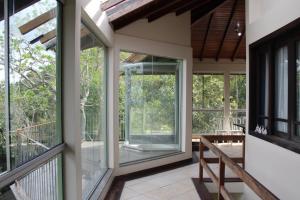 a screened in porch with windows and a bench at Pousada Laura e Emílio in Osório