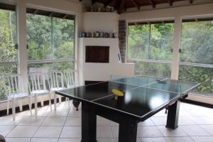 a ping pong table in a room with windows at Pousada Laura e Emílio in Osório
